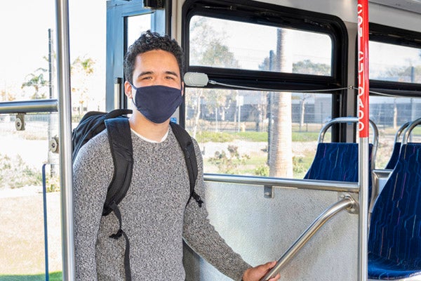 man wearing mask entering the bus