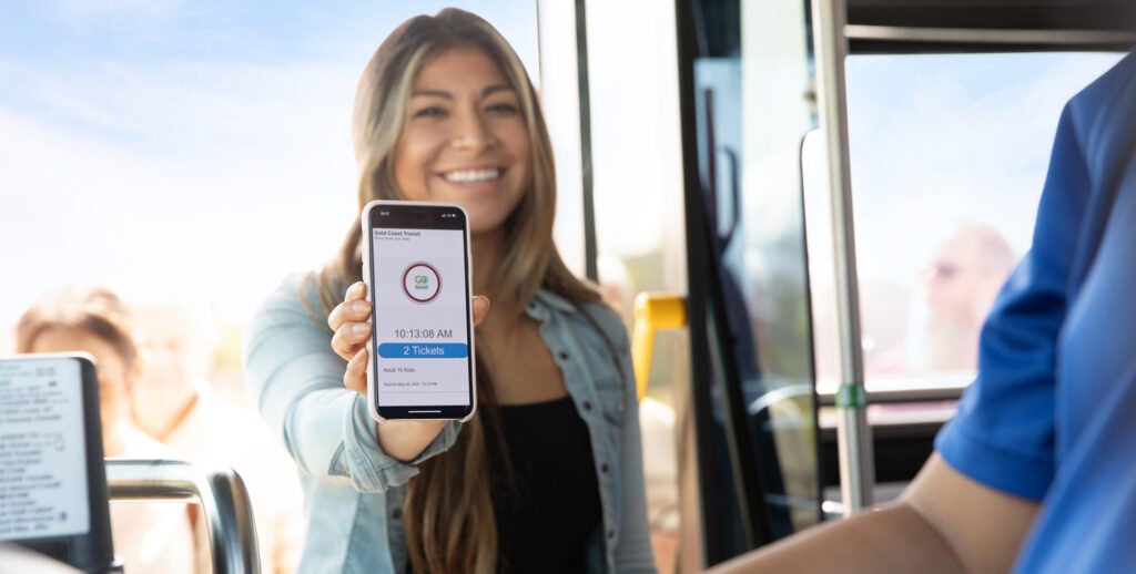 woman holding up mobile pass on her phone