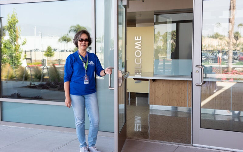 admin employee standing in front of the admin building